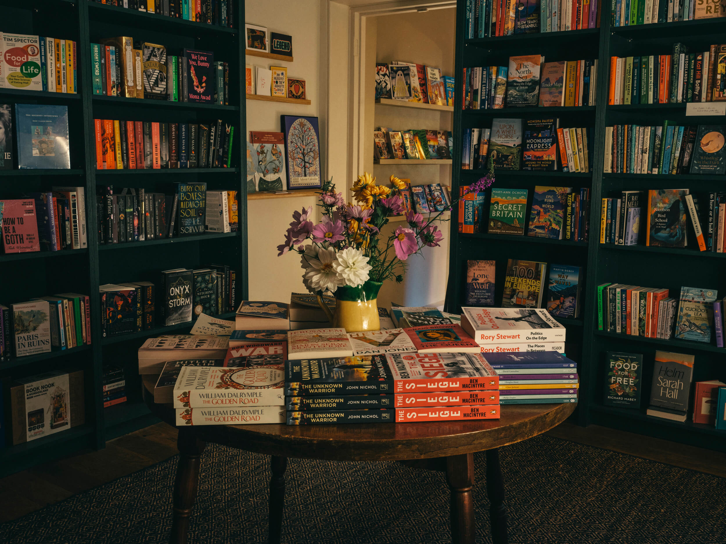 Wide interior view of Fox & King, Independent Bookshop in Tisbury, showing tall bookshelves, curated displays, wooden floors, and soft natural light creating a calm, literary atmosphere.